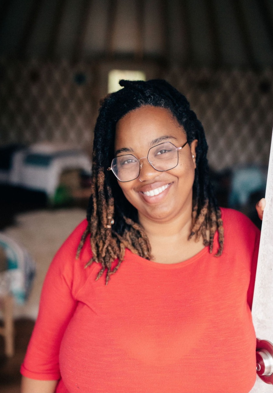 Rashida McCoy smiling warmly, wearing glasses and a red shirt